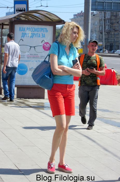 Высокая девушка в шортах стоит на остановке. (462x699, 61Kb)