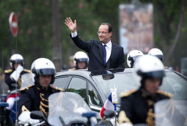 François Hollande, tout juste investi président de la République, salue la foule depuis sa voiture alors qu'il quitte le Palais de l'Elysée après la cérémonie d'investiture pour rejoindre l'Arc de Triomphe en remontant (630x423, 45Kb)