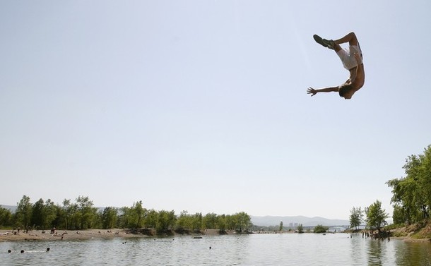 Человек прыгает в озеро, расположенное на острове Татищев посередине реки Енисей, Красноярск, 14 июня 2012 года.