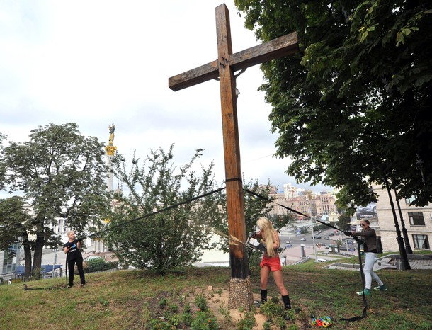 Активистка FEMEN спилила православный крест, воздвигнутый в память жертв политических репрессий, Киев, 17 августа 2012 года