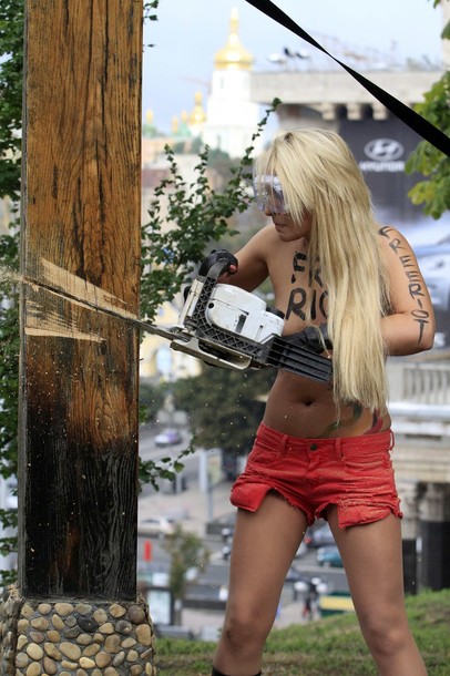 Активистка FEMEN спилила православный крест, воздвигнутый в память жертв политических репрессий, Киев, 17 августа 2012 года