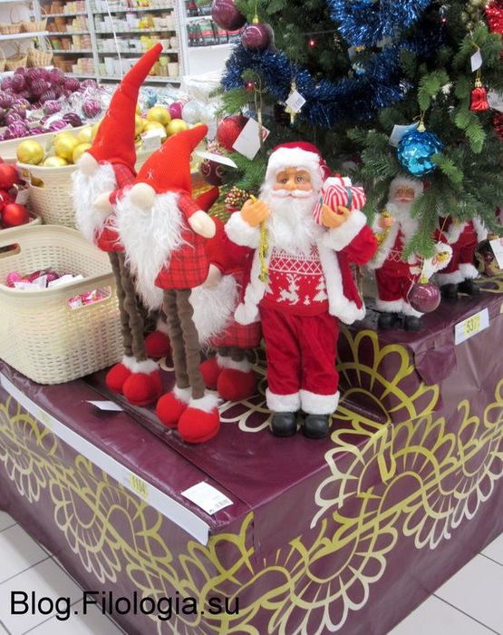 Небольшие фигурки Деда Мороза и гномов у новогодней елки в магазине "Ашан" в Москве. 