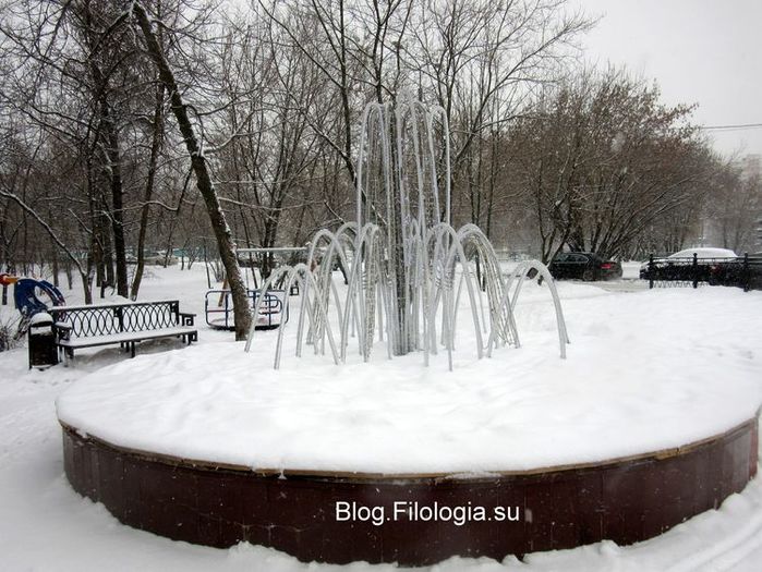 Зима. Снег. Отключенный фонтан и лавочки.