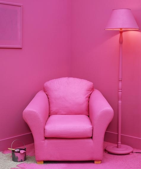 Paintbrush and can on floor in room with furniture painted pink
