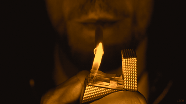 Зажигалка и сигареты в темноте. Мужчина с зажигалкой. Человек с зажигалкой в темноте. Закуривает от зажигалки. Одинокий мужчина не курит не пьет